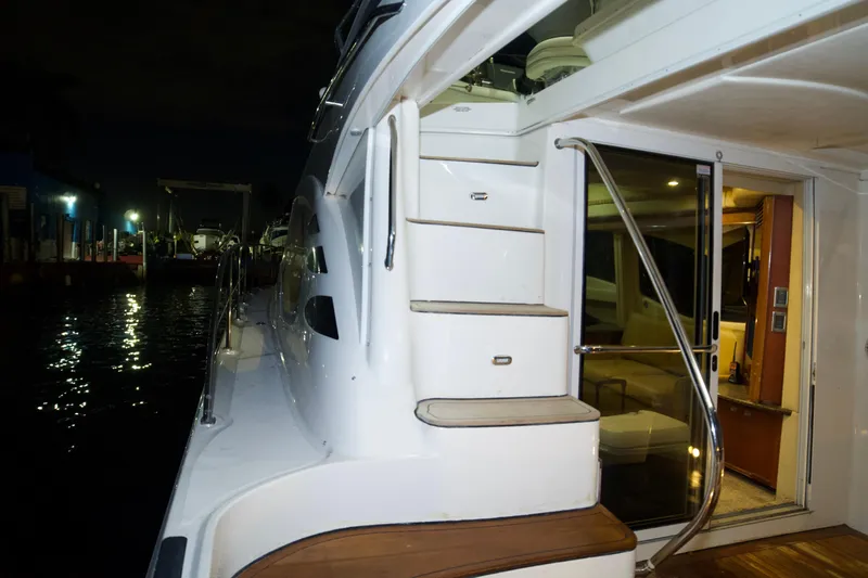  Yacht Photos Pics 2006 Sea Ray 44 Sedan Bridge yacht with illuminated deck and interior at night.