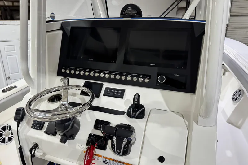  Yacht Photos Pics 2023 Regulator 28 boat dashboard with dual screens and steering wheel.