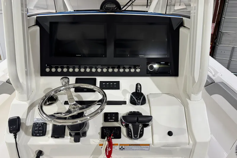  Yacht Photos Pics 2023 Regulator 28 boat dashboard with dual screens and steering wheel.