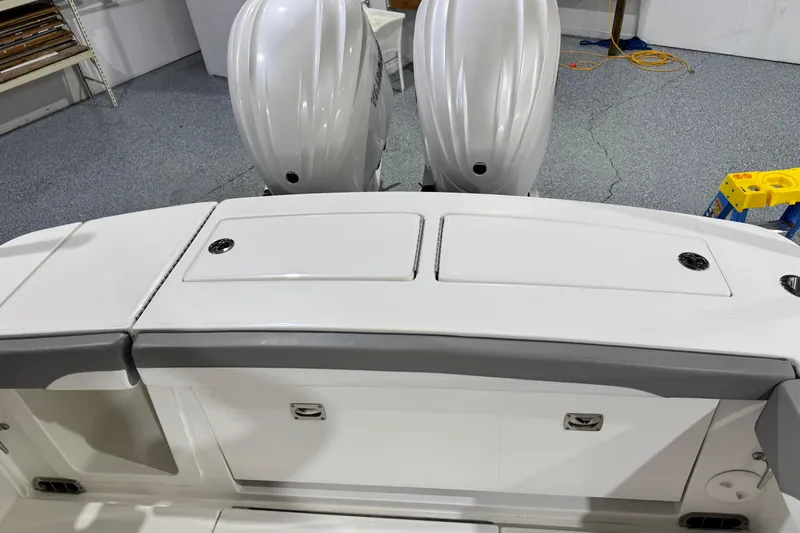 Yacht Photos Pics 2023 Regulator 28 boat with dual outboard engines in a garage setting.