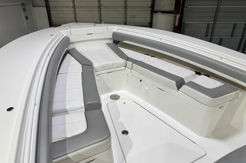  Yacht Photos Pics 2023 Regulator 28 boat interior with cushioned seating in a garage setting.