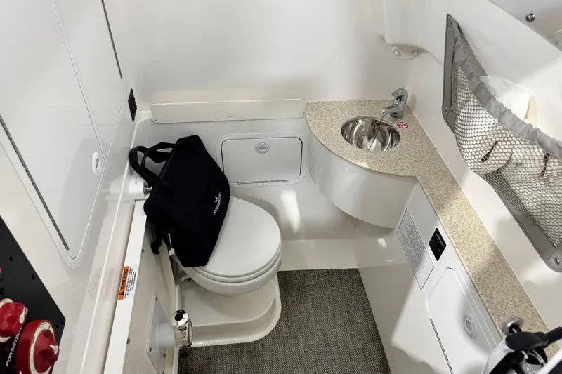  Yacht Photos Pics 2023 Regulator 28 boat interior with toilet, sink, and storage area.