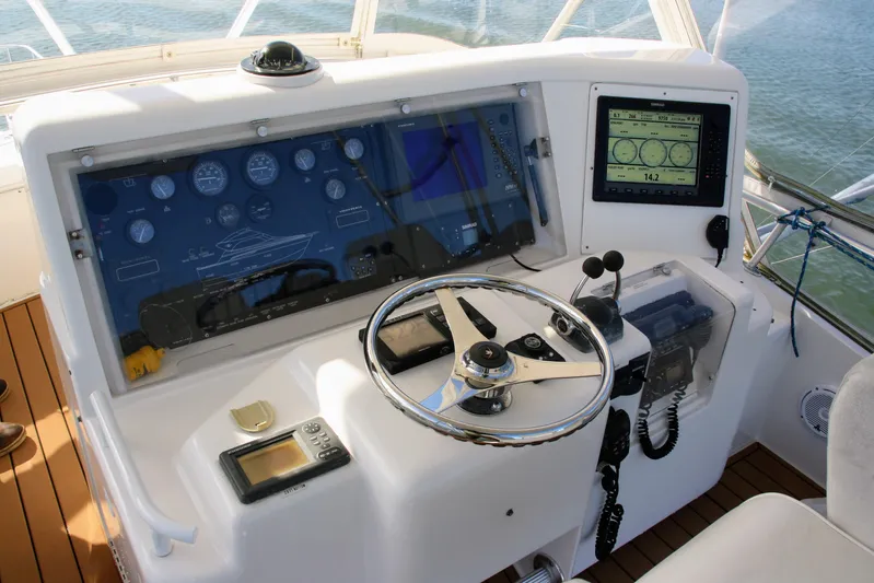 Lineage Yacht Photos Pics 2003 Bertram 390 Convertible helm with steering wheel, gauges, and navigation equipment.