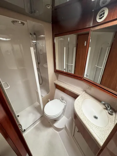 Lineage Yacht Photos Pics Bathroom interior of 2003 Bertram 390 Convertible yacht with shower, toilet, and sink.