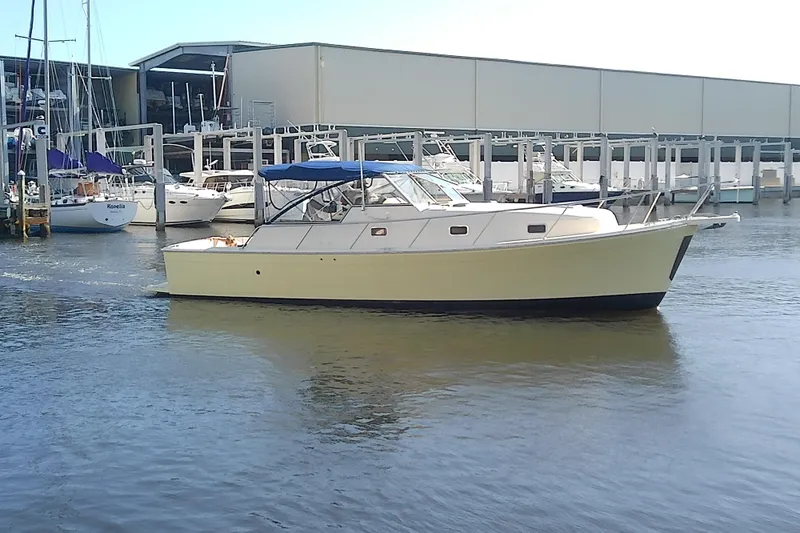 Dolce Far Niente Yacht Photos Pics 2004 Mainship 34 Pilot II yacht docked at marina with sailboats in background.