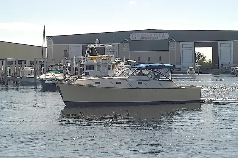 Dolce Far Niente Yacht Photos Pics 2004 Mainship 34 Pilot II yacht docked at marina with blue canopy.