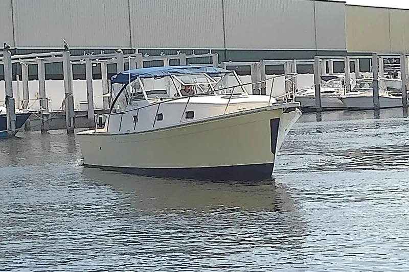 Dolce Far Niente Yacht Photos Pics 2004 Mainship 34 Pilot II boat docked in marina, featuring a blue canopy.