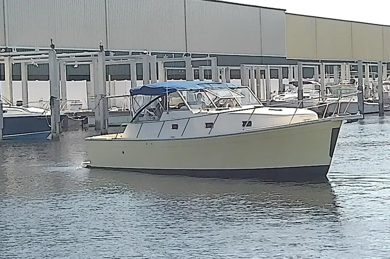 Dolce Far Niente Yacht Photos Pics 2004 Mainship 34 Pilot II boat docked at marina with blue canopy.