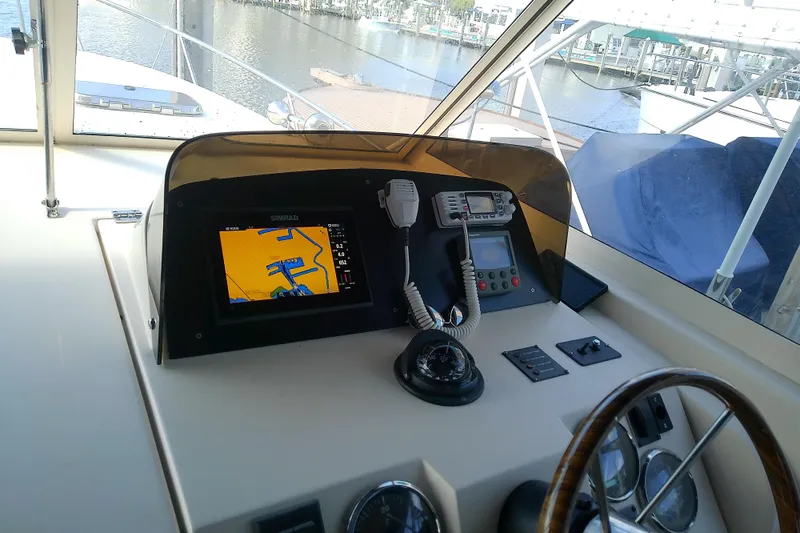 Dolce Far Niente Yacht Photos Pics 2004 Mainship 34 Pilot II helm with navigation equipment and waterfront view.