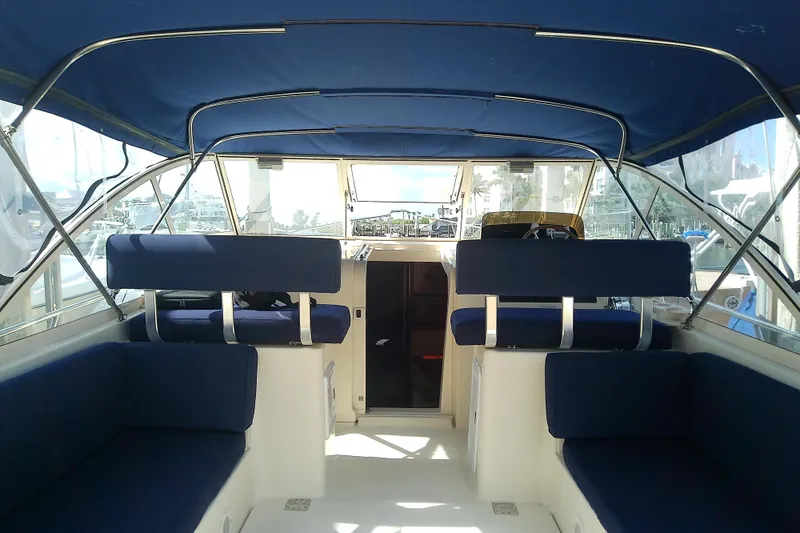 Dolce Far Niente Yacht Photos Pics Interior view of 2004 Mainship 34 Pilot II boat with blue seating and canopy.
