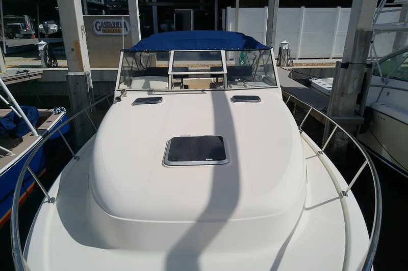 Dolce Far Niente Yacht Photos Pics 2004 Mainship 34 Pilot II boat docked at marina with blue canopy.