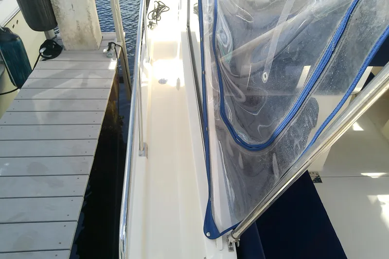 Dolce Far Niente Yacht Photos Pics 2004 Mainship 34 Pilot II docked, featuring clear canopy and white deck.