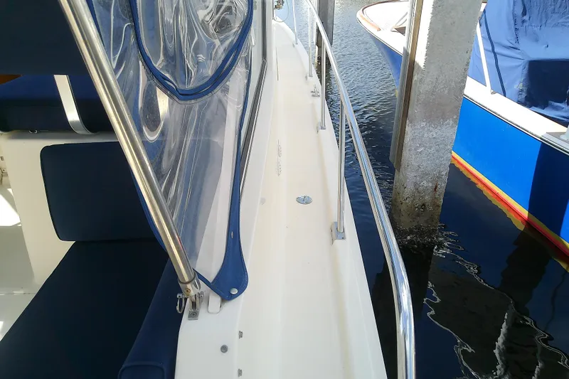 Dolce Far Niente Yacht Photos Pics 2004 Mainship 34 Pilot II boat docked, featuring blue seating and clear canopy.