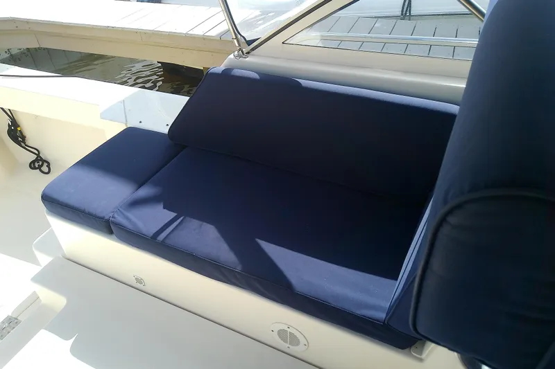 Dolce Far Niente Yacht Photos Pics Blue cushioned seating on 2004 Mainship 34 Pilot II boat deck, under sunlight.