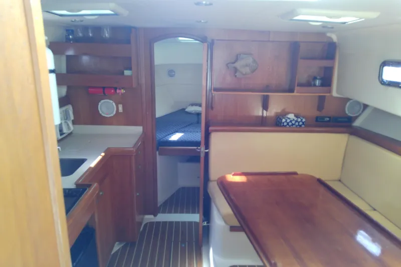 Dolce Far Niente Yacht Photos Pics 2004 Mainship 34 Pilot II interior with wood cabinetry and cozy seating area.