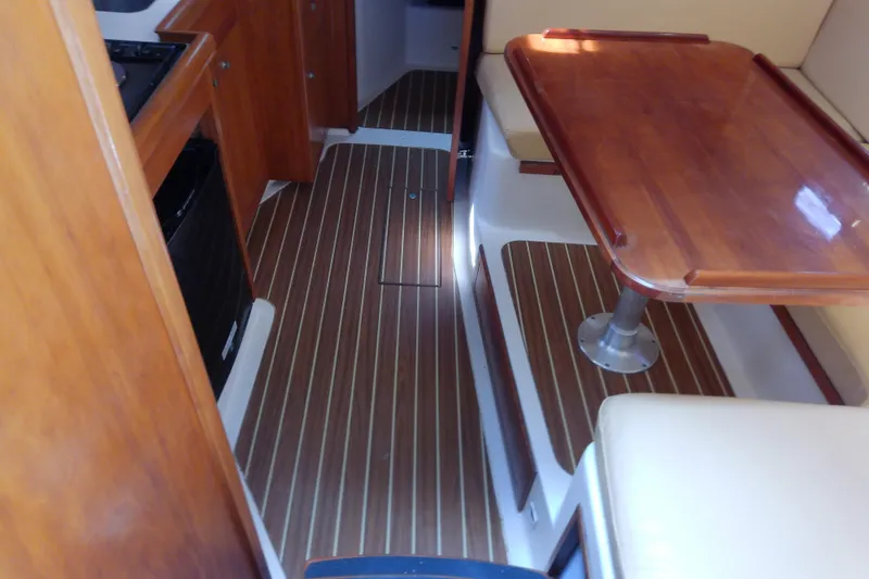 Dolce Far Niente Yacht Photos Pics Interior of 2004 Mainship 34 Pilot II with wood flooring and dining area.