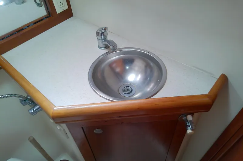 Dolce Far Niente Yacht Photos Pics 2004 Mainship 34 Pilot II boat bathroom sink with wooden trim and modern faucet.