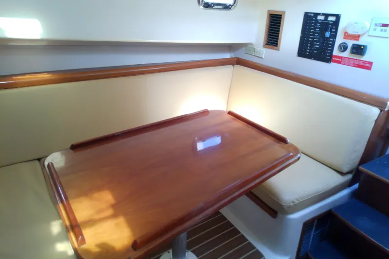 Dolce Far Niente Yacht Photos Pics 2004 Mainship 34 Pilot II cabin with wooden table and cushioned seating.