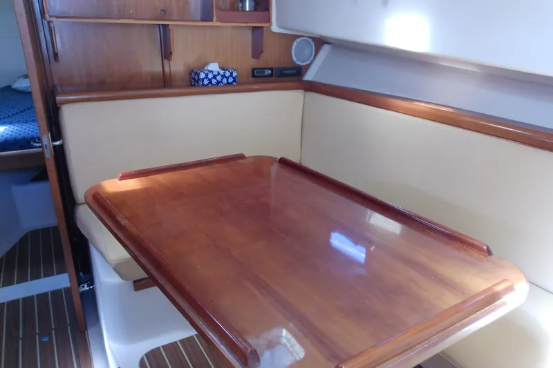 Dolce Far Niente Yacht Photos Pics 2004 Mainship 34 Pilot II interior with wooden table and beige seating.