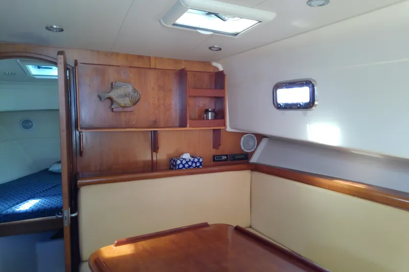 Dolce Far Niente Yacht Photos Pics 2004 Mainship 34 Pilot II interior with wood cabinetry and cozy seating area.