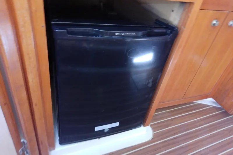 Dolce Far Niente Yacht Photos Pics Black refrigerator in the cabin of a 2004 Mainship 34 Pilot II boat.