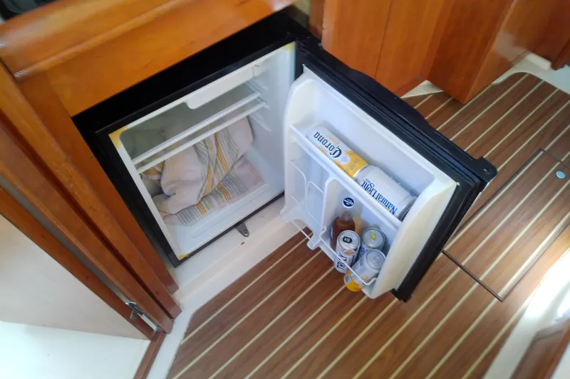 Dolce Far Niente Yacht Photos Pics Open mini fridge on 2004 Mainship 34 Pilot II boat with drinks and towels inside.