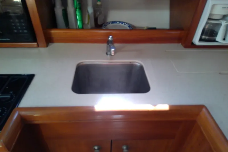 Dolce Far Niente Yacht Photos Pics 2004 Mainship 34 Pilot II kitchen sink with wooden cabinetry and countertop.