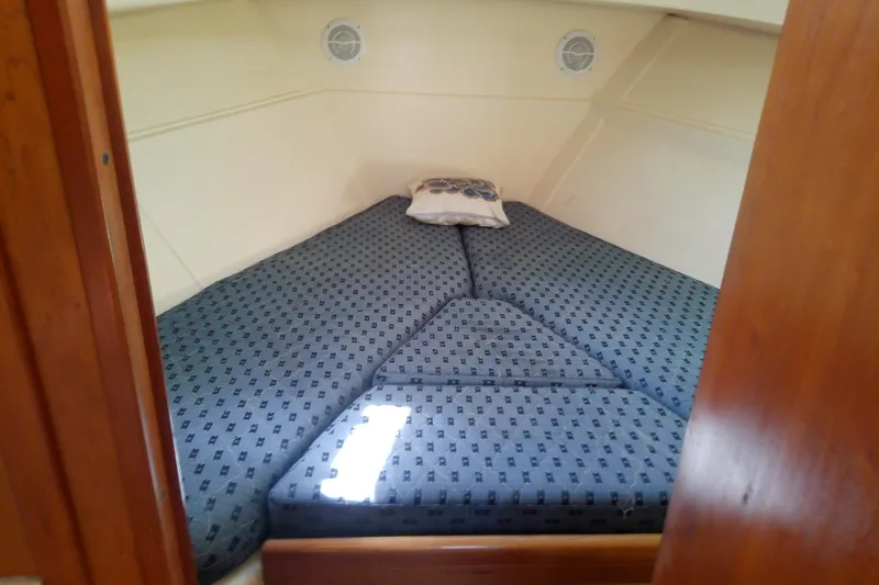 Dolce Far Niente Yacht Photos Pics Cozy cabin interior of 2004 Mainship 34 Pilot II with patterned bedding.