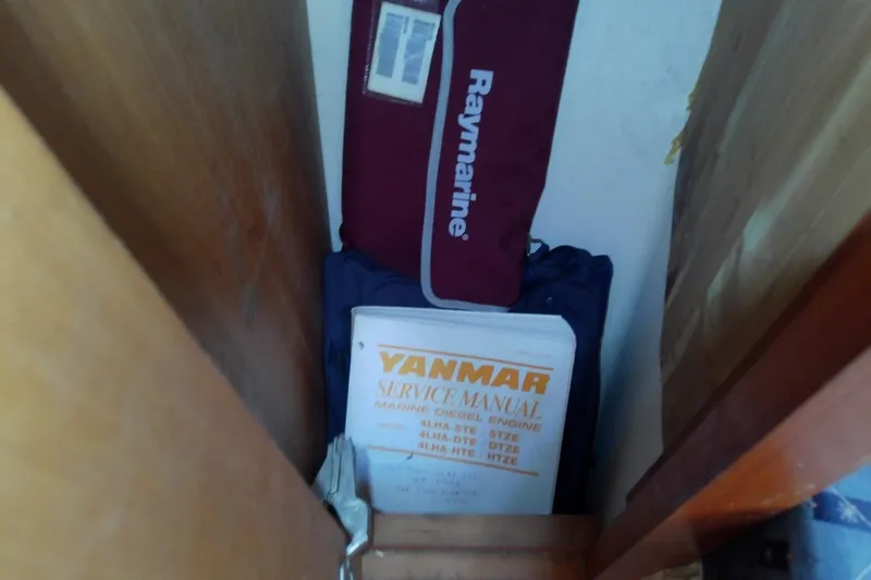 Dolce Far Niente Yacht Photos Pics Storage area with Yanmar service manual and Raymarine bag on Mainship 34 Pilot II, 2004.