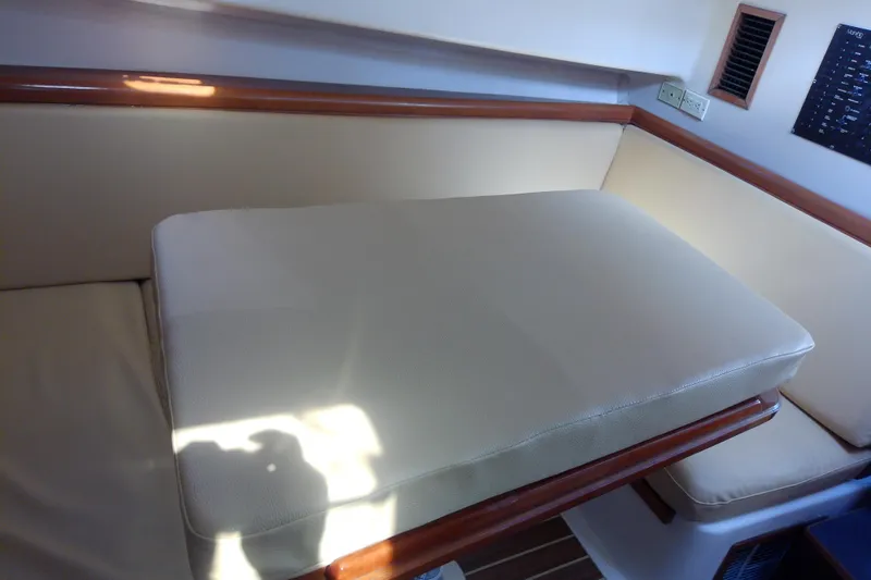 Dolce Far Niente Yacht Photos Pics Interior seating area of a 2004 Mainship 34 Pilot II boat with beige cushions.
