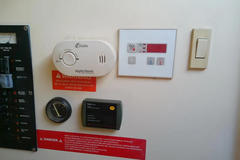 Dolce Far Niente Yacht Photos Pics Control panel with safety warnings and devices on a 2004 Mainship 34 Pilot II boat.