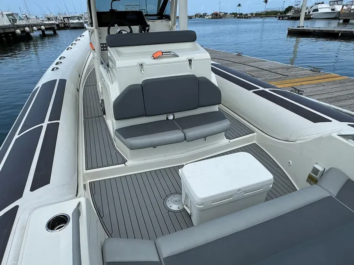  Yacht Photos Pics 2022 Brig Eagle 10 boat interior with seating and cooler at marina dock.