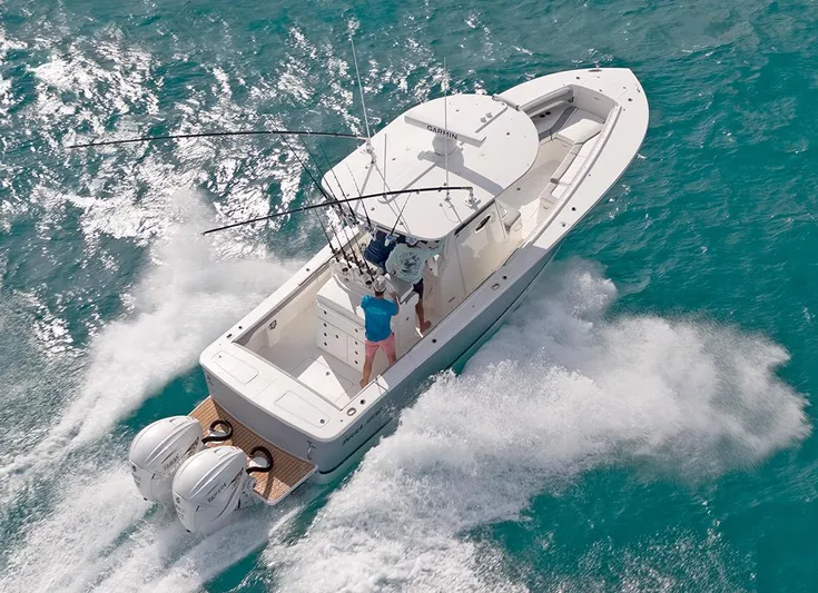  Yacht Photos Pics 2022 Regulator 31 boat cruising on turquoise waters with fishing rods.