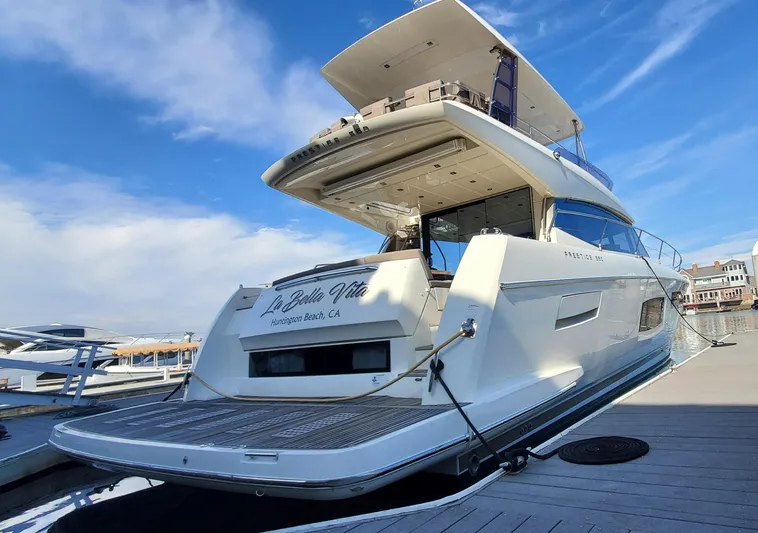" La Bella Vita" Yacht Photos Pics Prestige 560 Flybridge yacht, 2017 model, docked at a marina under a clear blue sky.