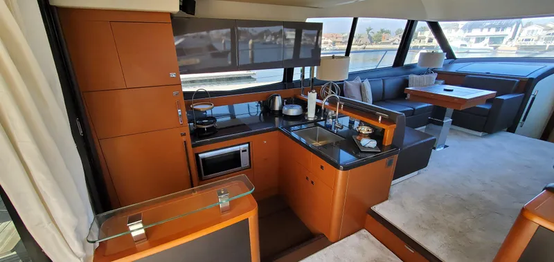 " La Bella Vita" Yacht Photos Pics Luxurious interior of a 2017 Prestige 560 Flybridge yacht with modern kitchen and seating area.