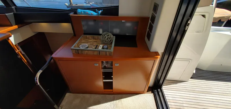 " La Bella Vita" Yacht Photos Pics Interior of 2017 Prestige 560 Flybridge yacht with wooden cabinetry and decorative items.