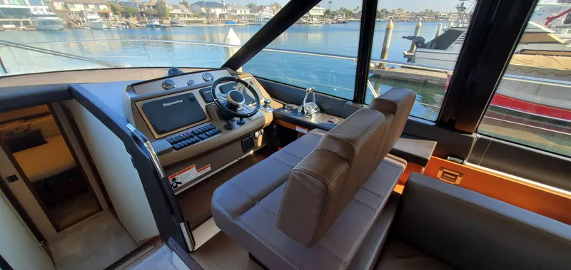 " La Bella Vita" Yacht Photos Pics Interior view of 2017 Prestige 560 Flybridge yacht helm with waterfront background.