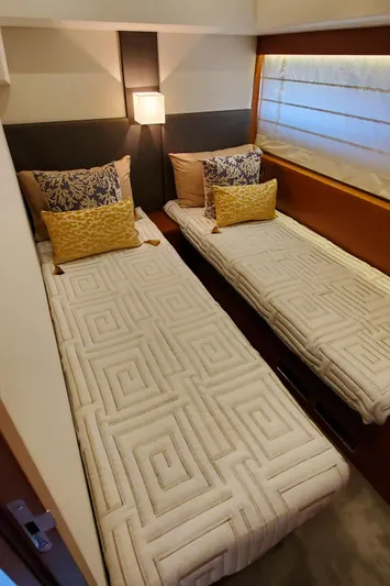 " La Bella Vita" Yacht Photos Pics Twin beds in a 2017 Prestige 560 Flybridge yacht cabin, featuring elegant bedding and decor.