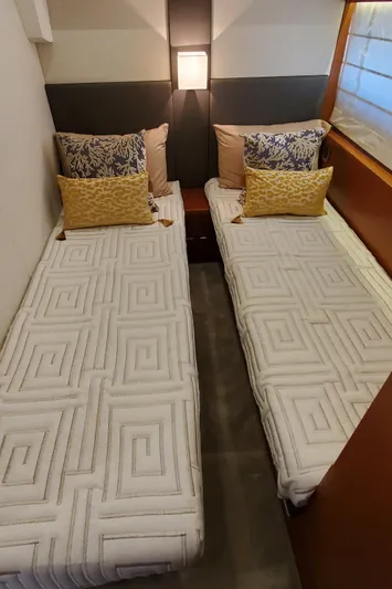 " La Bella Vita" Yacht Photos Pics Twin beds in a 2017 Prestige 560 Flybridge yacht cabin, featuring elegant bedding and modern lighting.