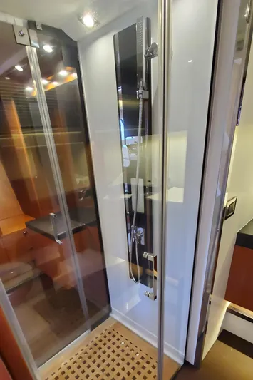 " La Bella Vita" Yacht Photos Pics Luxurious shower in 2017 Prestige 560 Flybridge yacht with modern fixtures and wooden flooring.