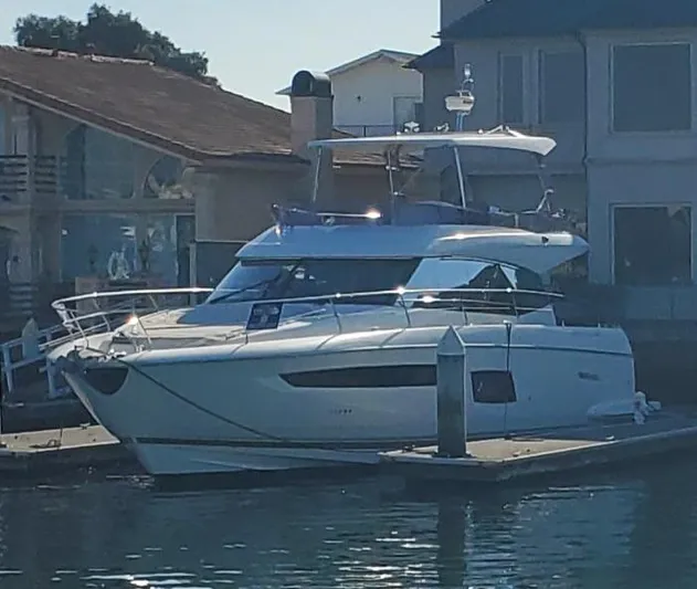 " La Bella Vita" Yacht Photos Pics 2017 Prestige 560 Flybridge yacht docked at a marina, with waterfront homes in the background.
