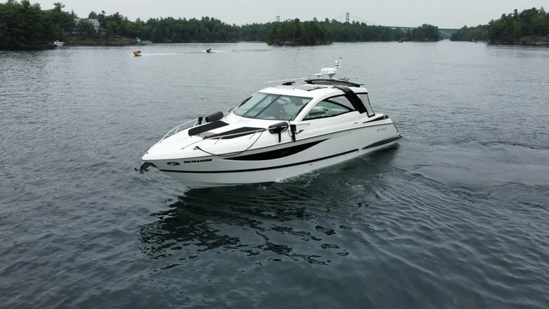  Yacht Photos Pics 2016 Cobalt A40 boat cruising on a calm lake with forested shoreline.