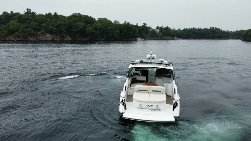  Yacht Photos Pics 2016 Cobalt A40 boat cruising on a serene lake with lush green shoreline.