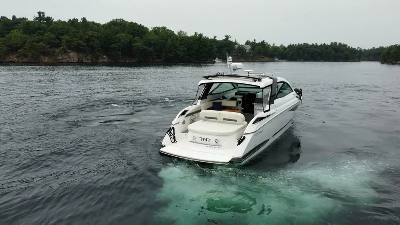  Yacht Photos Pics 2016 Cobalt A40 boat cruising on a serene lake with lush green shoreline.