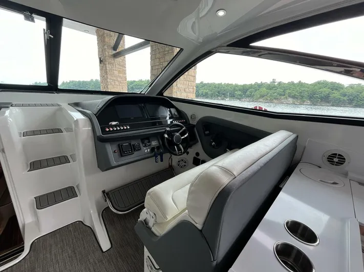  Yacht Photos Pics Interior of a 2016 Cobalt A40 boat with steering wheel and seating.