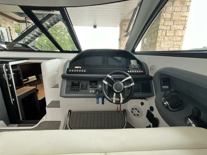  Yacht Photos Pics Interior view of 2016 Cobalt A40 boat cockpit with steering wheel and control panel.