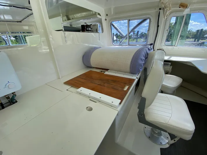 Mirage Yacht Photos Pics Interior of a 1996 Custom 62 boat with seating and wooden table.