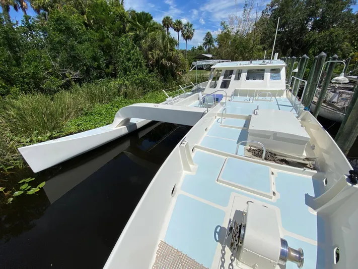 Mirage Yacht Photos Pics Custom 62 boat from 1996 docked near lush greenery and calm water.