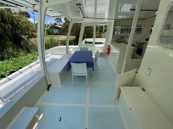 Mirage Yacht Photos Pics Spacious boat interior with table, chairs, and kitchen area, Custom model 62, 1996.