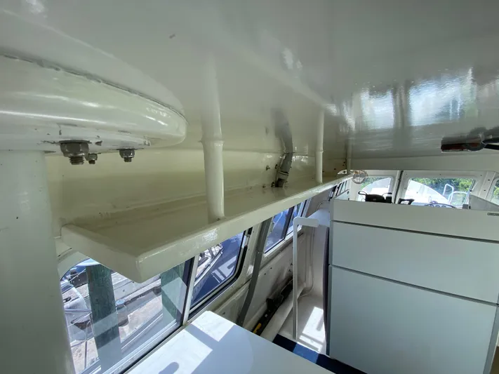 Mirage Yacht Photos Pics Interior of a 1996 Custom 62 boat, showcasing white cabinetry and windows.